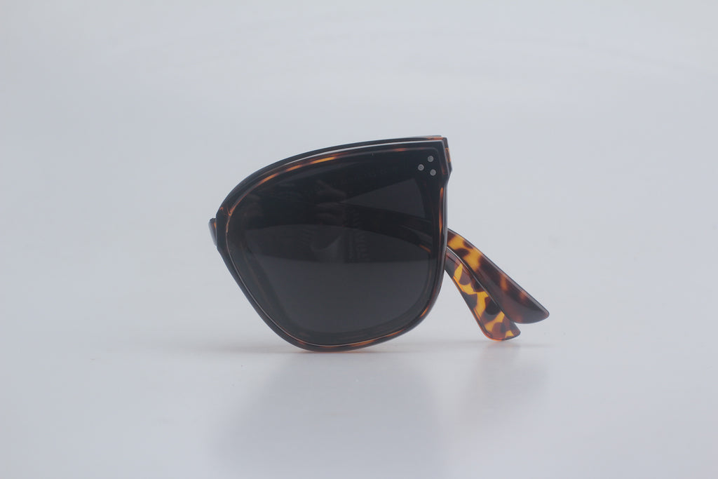 Luxury tortoiseshell aviator sunglasses featuring premium TR90 frames in mottled brown patterns, high-contrast dark polarized lenses for glare-free vision, strategically folded on crisp white canvas for upscale sunglasses inventory, sophisticated UV safeguarding eyewear, timeless rectangular style shades, elite fashion optic enhancements, versatile outdoor eye armor essentials.