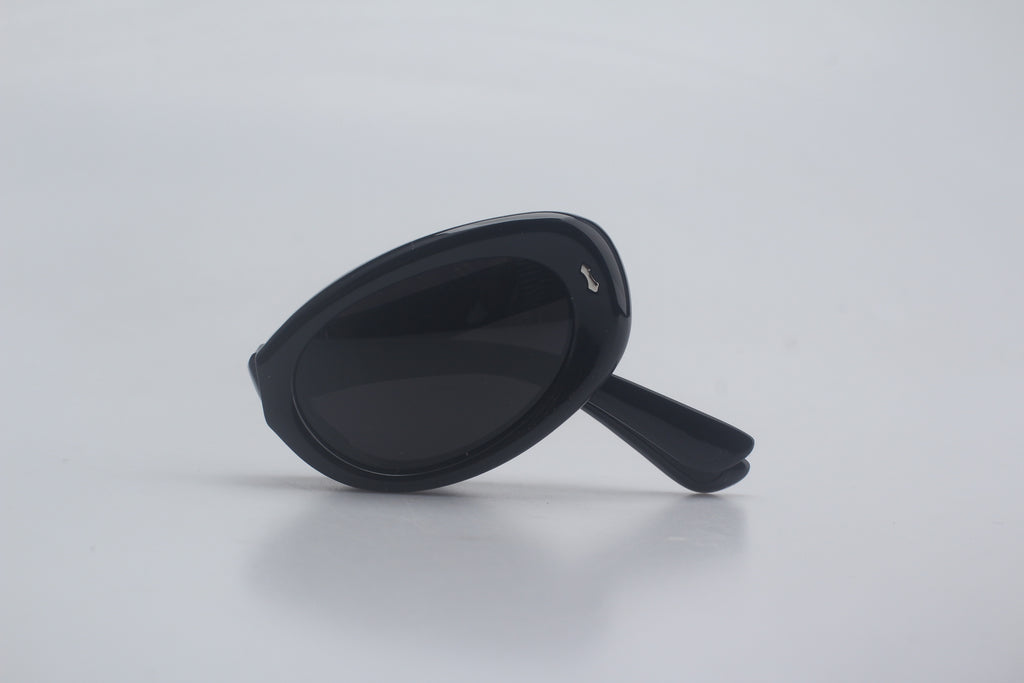 Glossy black polarized sunglasses with cat eye TR90 frames, anti-glare dark tinted lenses, rubber grip temples and nose pads for enhanced comfort and non-slip fit, shown folded on plain white background for designer eyewear catalog, premium UV blocking shades, vintage retro sunnies, high-quality optical gear, outdoor adventure sun glasses, fashion eye protection accessories.